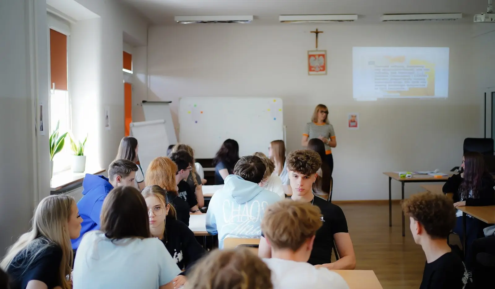 Debata w klasie szkolnej – uczennice i uczniowie słuchają prezentacji